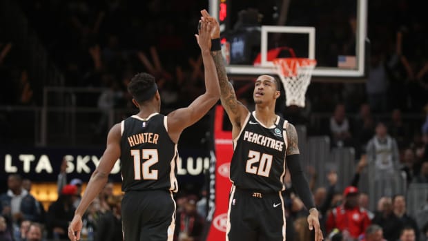 Jan 22, 2020; Atlanta, Georgia, USA; Atlanta Hawks forward De'Andre Hunter (12) celebrates a three-point basket with forward John Collins (20) in the fourth quarter against the LA Clippers at State Farm Arena.
